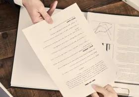 One person passing a document to another person