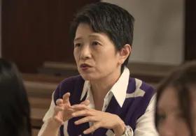 A female student speaking in a lecture hall.