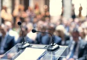 Lectern with microphones and a blurred out audience