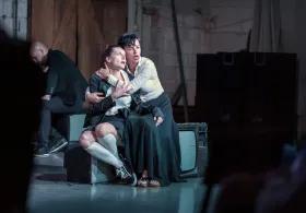 Two actors on a stage embracing