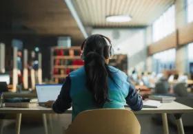 Student at desk with headphones on