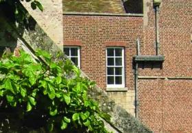 A close up photo of Madingley hall roof, building and windows.  