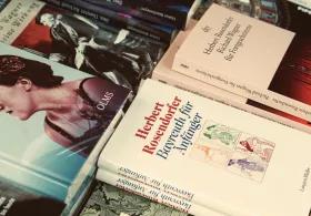 A close-up view of several books scattered on a surface, with German titles visible on their covers.