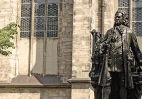 A bronze statue of Johann Sebastian Bach stands in front of St. Thomas Church in Leipzig, Germany. 