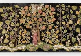 A late 16th-century British embroidered textile depicting 'The Garden of Eden' on dark velvet, featuring vibrant green trees laden with colorful fruits, flowers, and leaves, with figures of Adam and Eve amidst the lush landscape and various animals.