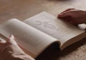 An open book on a wooden table.