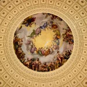 Figurative painting in a circular frame of a domed ceiling, viewed from below. 