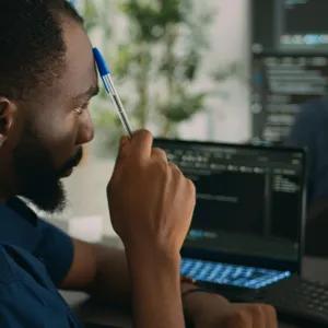 Man working in an office looking at two computer screens