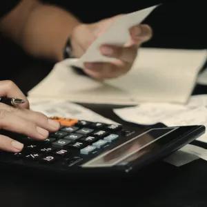 Student with calculator, bills and receipts