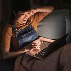 Woman with laptop on sofa 