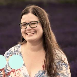 woman with long brown hair and glasses smiling for photo 