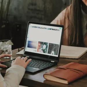Friends sitting at table with laptops learning online