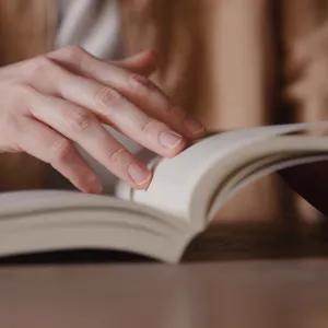 Hands turning pages of a book