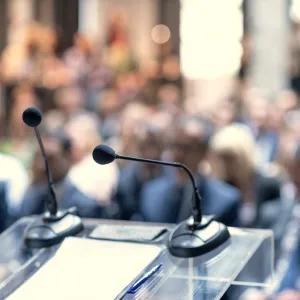 Lectern with microphones and a blurred out audience