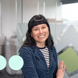 Women smiling with black hair and blue jacket