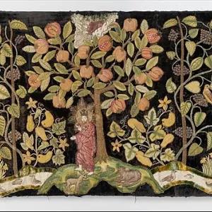 A late 16th-century British embroidered textile depicting 'The Garden of Eden' on dark velvet, featuring vibrant green trees laden with colorful fruits, flowers, and leaves, with figures of Adam and Eve amidst the lush landscape and various animals.
