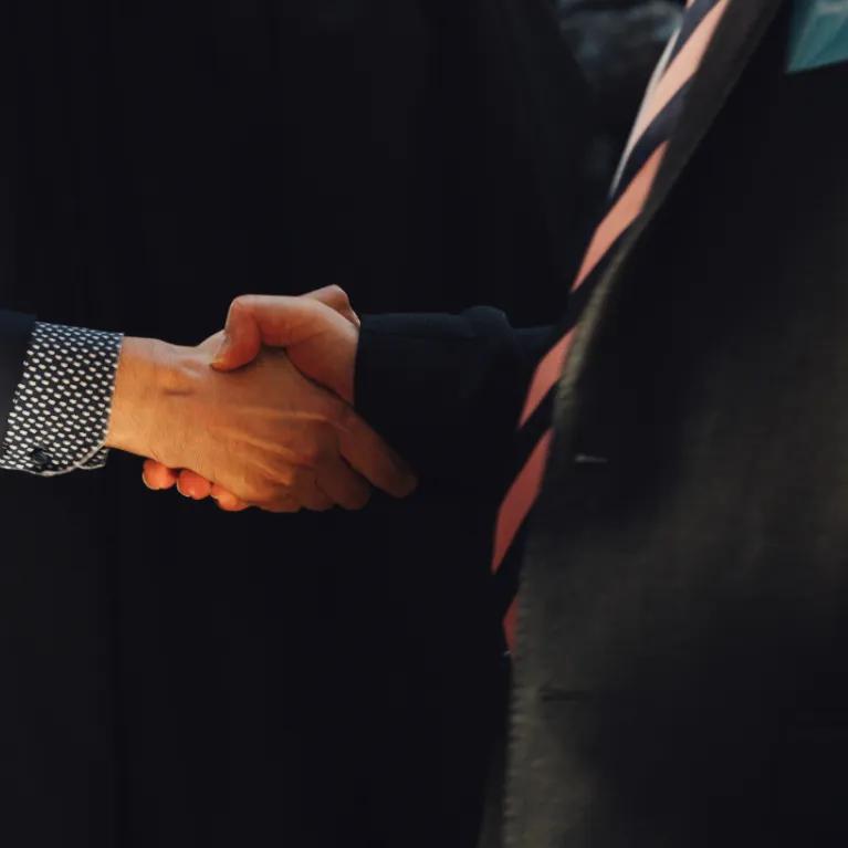 A close up two people shaking hands.
