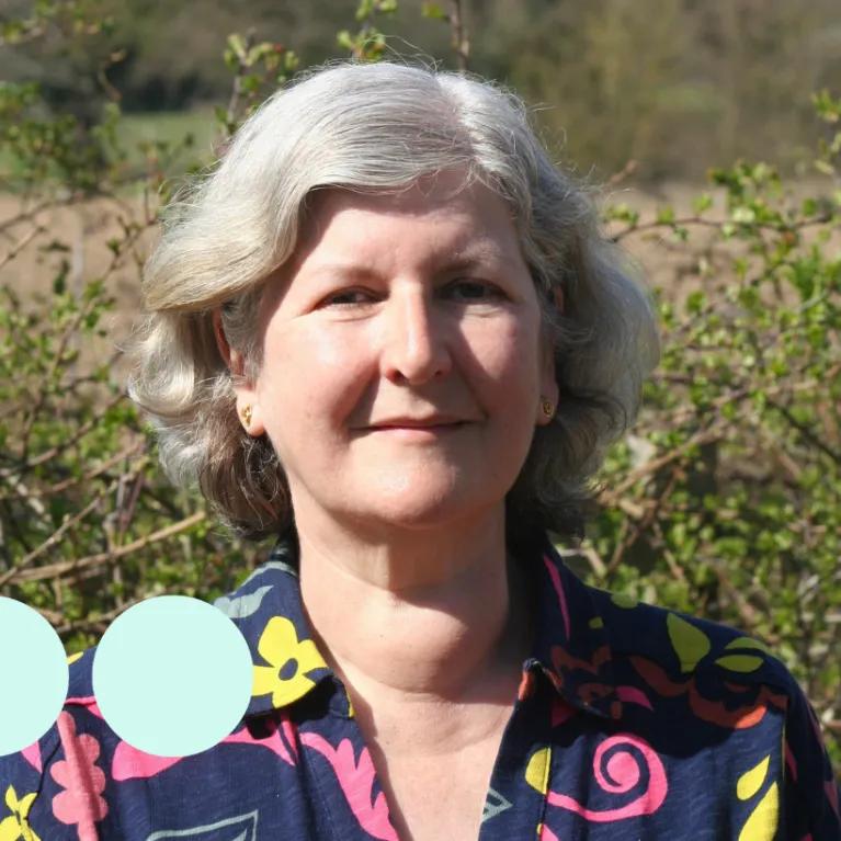 Older woman with silver short wavy hair 