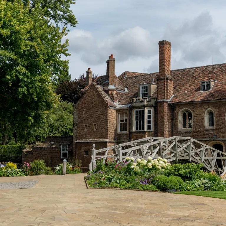 The exterior of Queens' College with the mathematical bridge in the foreground.