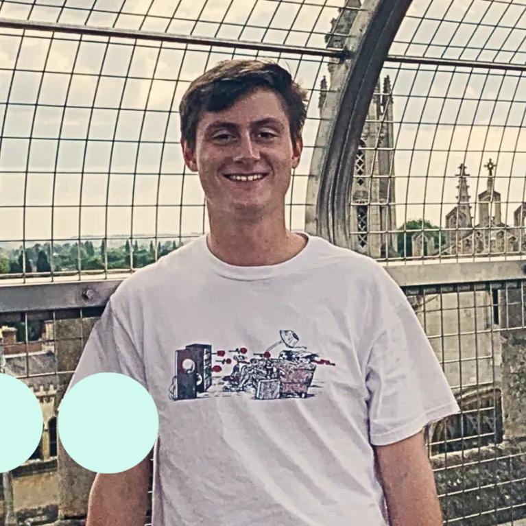 Young man with brown hair smiling for photo