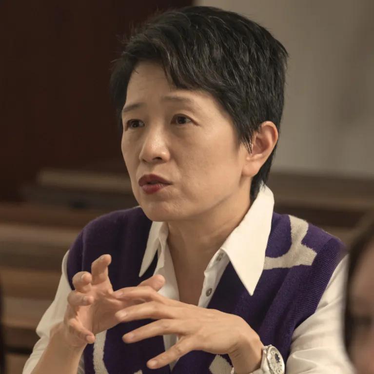 A female student speaking in a lecture hall.