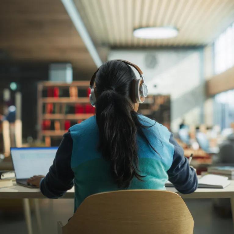 Student at desk with headphones on