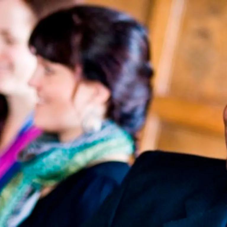 3 people listening to a seminar at a coaching group workshop.