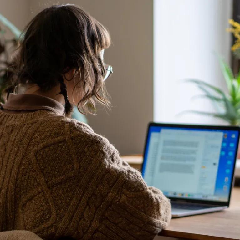 woman sat at laptop in home office