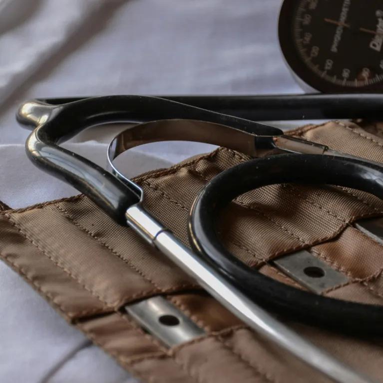 Close-up of a historical doctor's kit, a pouch including a stethoscope and other medical instruments. 
