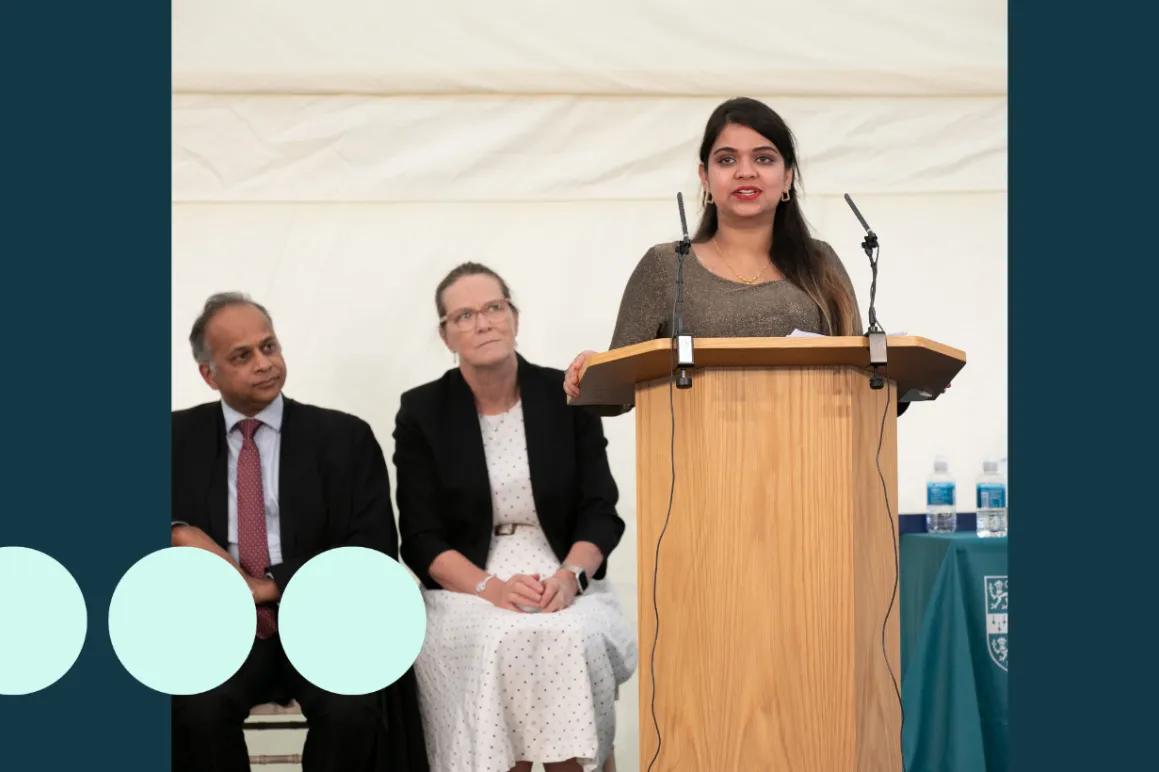 woman stood at podium delivery a speech