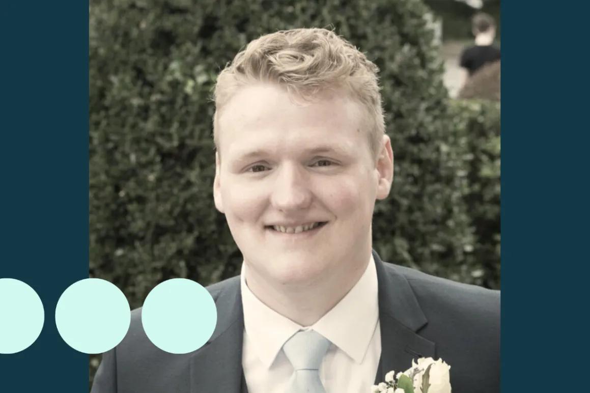 man with light blonde hair, in suit smiling for photo 