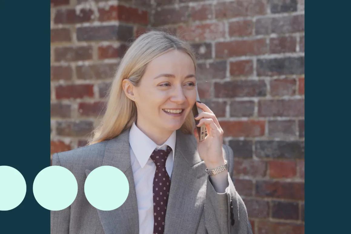 Blonde woman wearing suit, walking and talking on a mobile phone