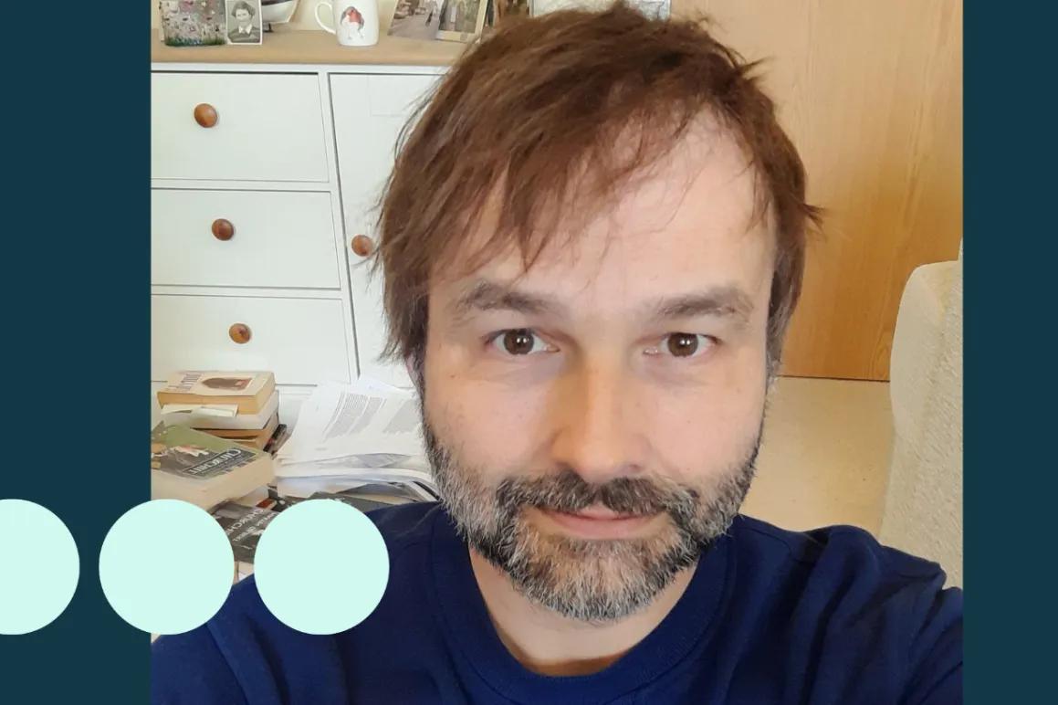 Man with dark hair and greying stubble